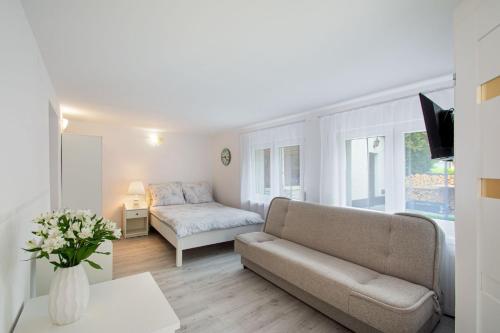 a living room with a couch and a bed at Leokadia przy plaży kwatery prywatne in Mielno