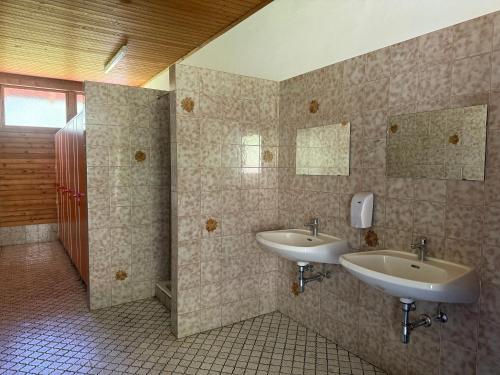 a bathroom with two sinks and two mirrors at Berg & See Hideaway in Mitterstein