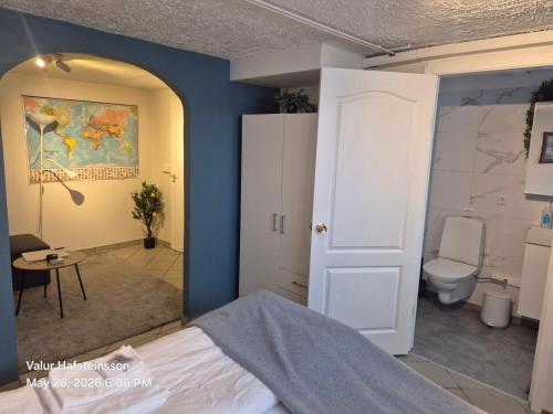 a bedroom with a bed and a bathroom with a toilet at Basement hideaway in Akureyri