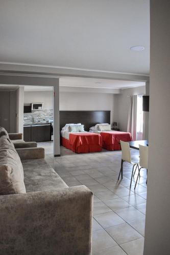 a living room with a couch and a bed at Demetrio Hotel Apart in Olavarría