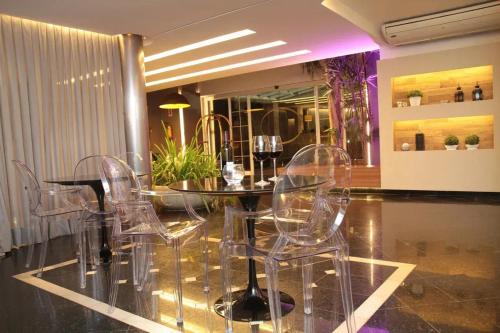 a dining room with clear chairs and a table at Oasis Plaza Hotel in Ribeirão Preto