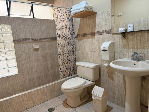 a bathroom with a toilet and a sink at Hotel El Brujo Centro Histórico in Trujillo