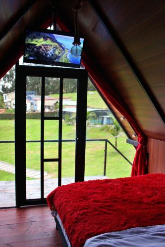 a room with a bed and a window with a screen at Hotel Rancho Olimpo in Sesquilé