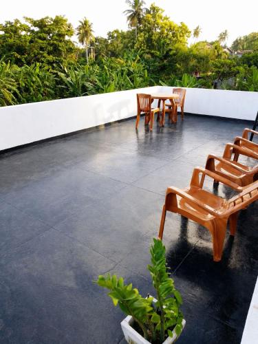 a patio with chairs and a table on a roof at Tropical Suites - Airport Transit Residence in Negombo