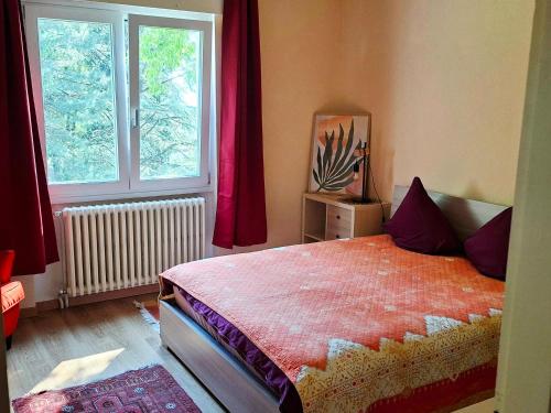 a bedroom with a bed with red curtains and a window at Gemütliche Ferienwohnung in Agra in Agra