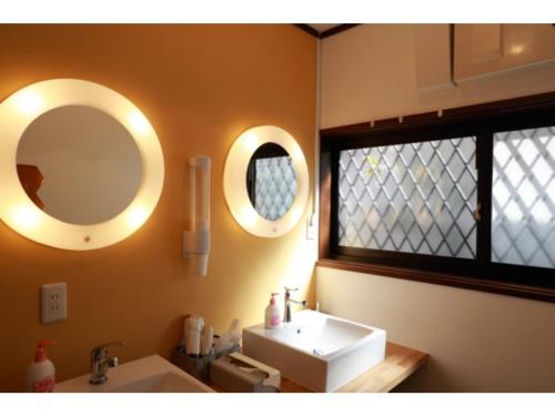 a bathroom with a sink and two mirrors on the wall at THINK - Vacation STAY 30630v in Ichigaya