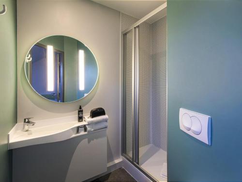 a bathroom with a sink and a mirror at ibis budget Grenoble Voreppe in Voreppe