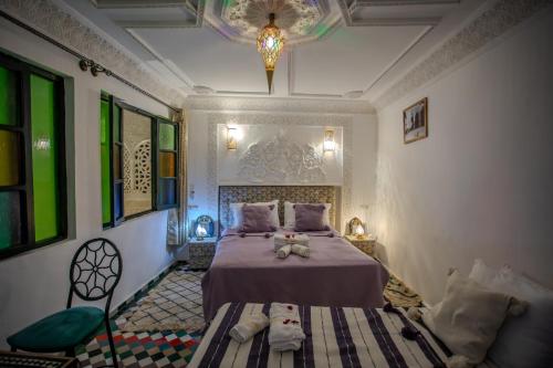 a bedroom with a bed and a chair in a room at Riad YAMNA - Quiet Desire in Fez