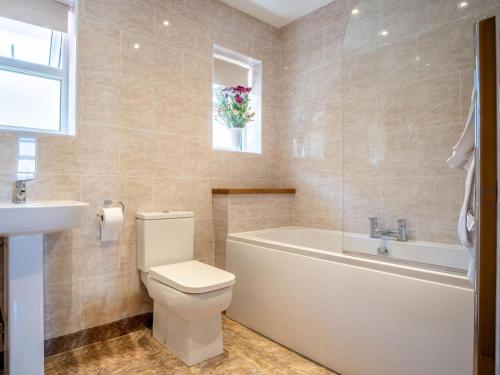 a bathroom with a toilet and a tub and a sink at 3 Bed in Shanklin oc-ic180 in Shanklin