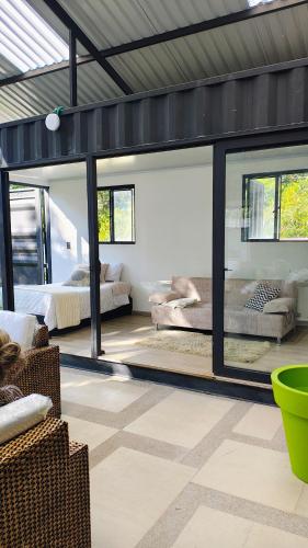 a living room with two beds and windows at Cabaña el Pilar in Fusagasuga