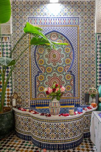 a bathroom with a tub with a vase of flowers at Riad YAMNA - Quiet Desire in Fez