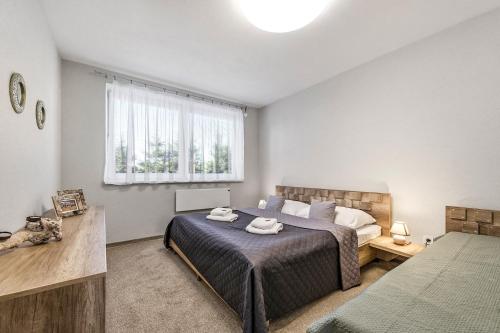 a bedroom with a large bed and a window at Apartmán Zara in Telgárt