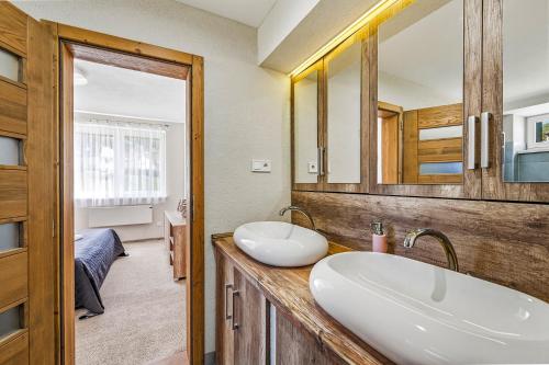 a bathroom with two sinks and a mirror at Apartmán Zara in Telgárt