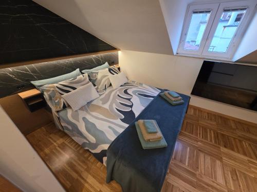 a bedroom with a bed with a blue blanket and pillows at Apartmaji Sonce in Piran
