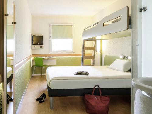 a hotel room with a bed and a sink at Ibis Budget Hyères in Hyères