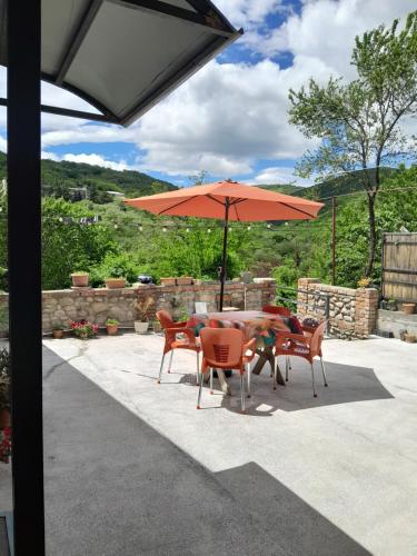 a table and chairs under an umbrella on a patio at Guest house Babaka in Sighnaghi