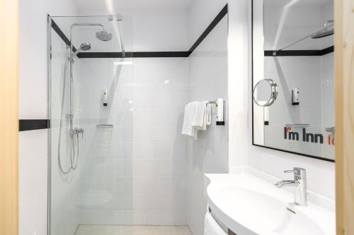 a white bathroom with a shower and a sink at I´m Inn Wieselburg in Wieselburg