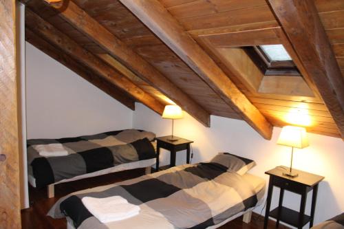 two beds in a room with wooden ceilings at Ski Andorra Tarter Chalet Lodge in El Tarter