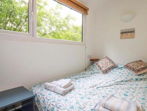 a bedroom with a bed with towels on it at Foxglove cabin in Bodmin