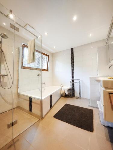 a bathroom with a tub and a glass shower at Ferienhaus Ströbl in Liesing