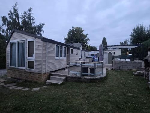 a tiny house with a deck in a yard at La cabane des fées in Yvoir
