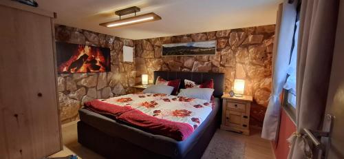 a bedroom with a stone wall with a bed at Ferienhaus Roseneck Bad Tabarz in Tabarz