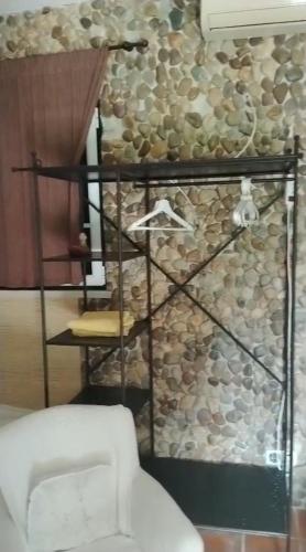 a room with a stone wall with a shelf and a chair at Monte dos Duques in Santo Estêvão