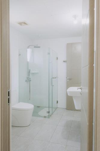 a bathroom with a toilet and a glass shower at Riverview Loft in Iloilo City