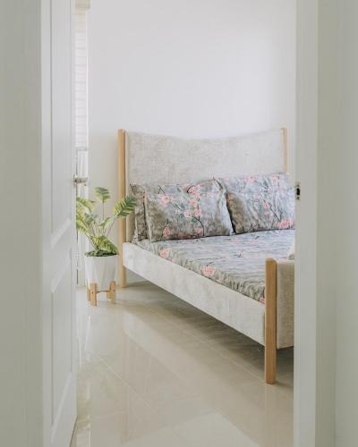 a bed in a white room with a plant at Riverview Loft in Iloilo City