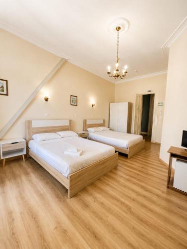 two beds in a large room with wooden floors at Central Guest House in Figueira da Foz