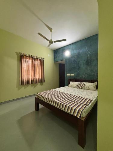 a bed in a room with a ceiling fan at The Luxora Villa in Kuilapayam