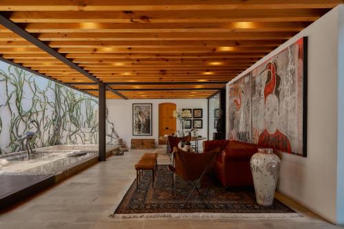 a living room with a large painting on the wall at Casa Carmen Xólotl in Oaxaca City