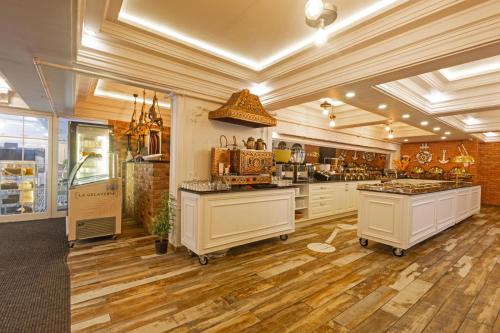 a large kitchen with wooden floors and white cabinets at Andalouse Otel in Trabzon