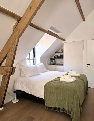 a bedroom with a large bed in a attic at Castle B&B Castanea in Merelbeke