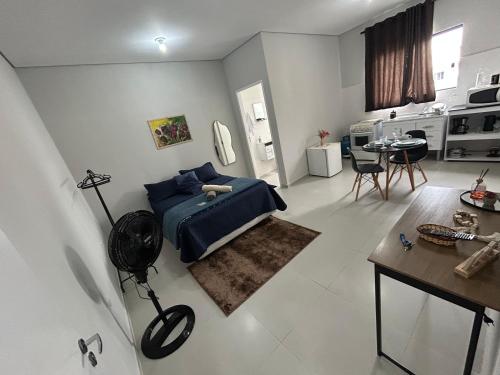 a bedroom with a blue bed and a table at 04 Studios centro,proximo a rodoviaria-itapeva sp in Itapeva