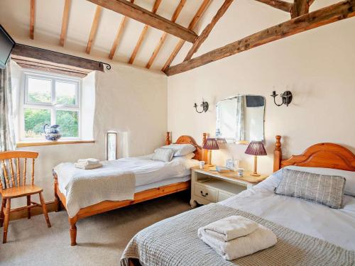 a bedroom with two beds and a desk and a mirror at 2 Bed in Conwy oc-95905 in Conwy