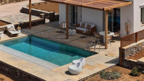 a swimming pool in a backyard with a house at Didimos Luxury Villas in Cherronisos