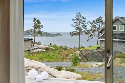 a view of the water from a house with eggs on a window at Seaside Escape - 10 Min to Ocean in Ytre Søndeled