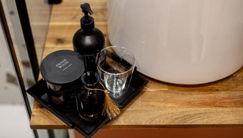 a black bottle and a glass on a table at Studio moderne chaleureux et calme in Annecy
