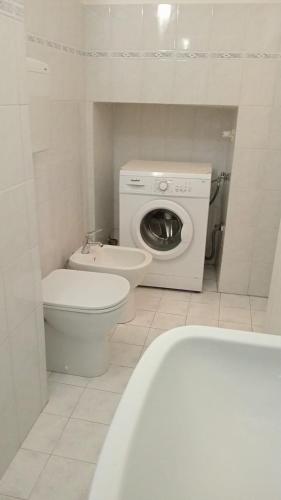 a bathroom with a toilet and a washing machine at La pergola in Sagliano Micca