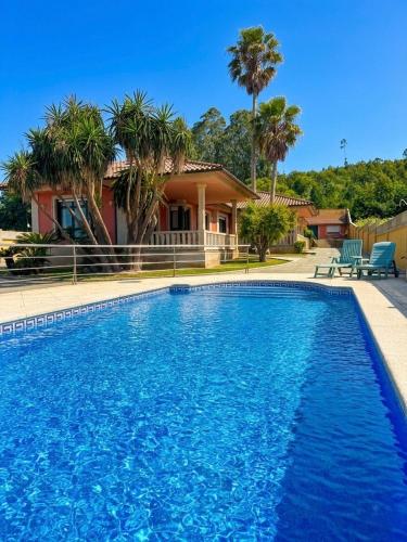 a house with a swimming pool in front of a house at La Pepa Sanxenxo in Sanxenxo
