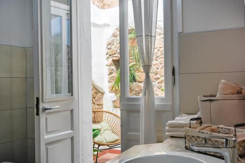 a bathroom with a sink and a door to a patio at Cozy guest house Downtown in Olbia