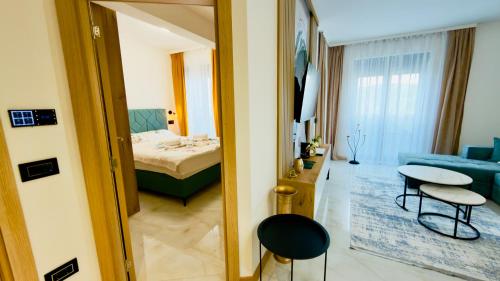 a room with a bed and a table and a couch at Apartman Romanija Wellness & Spa in Potoci