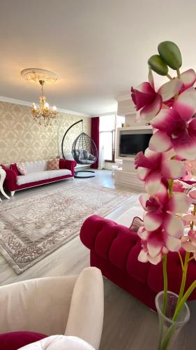 a living room with a red couch and a flower at My White Residence in Trabzon