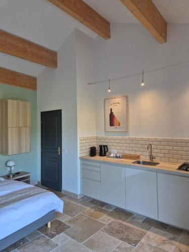 a kitchen with a bed and a sink in a room at Le Bos Dordogne in Soulaures