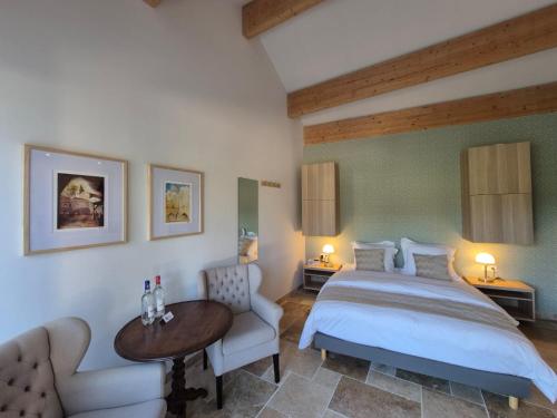 a bedroom with a bed and a table and a couch at Le Bos Dordogne in Soulaures