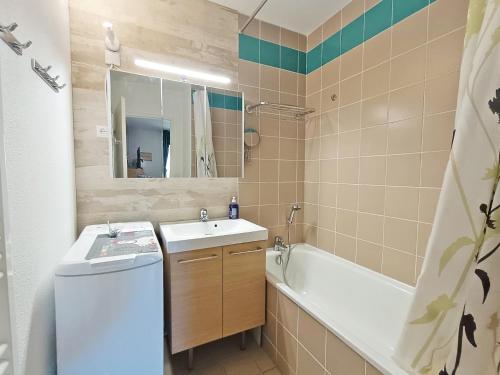 a bathroom with a sink and a tub and a toilet at Lia, T3, au calme, parking, internet in Luchon