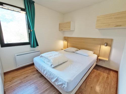 a bedroom with a large bed with a large window at Lia, T3, au calme, parking, internet in Luchon