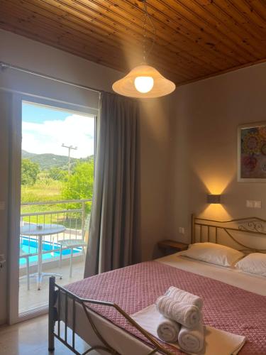 a bedroom with a bed and a balcony with a view at George Studios in Vasiliki