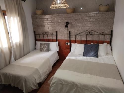 two beds sitting next to each other in a room at Casa Rural La Encina 2 in Lanjarón
